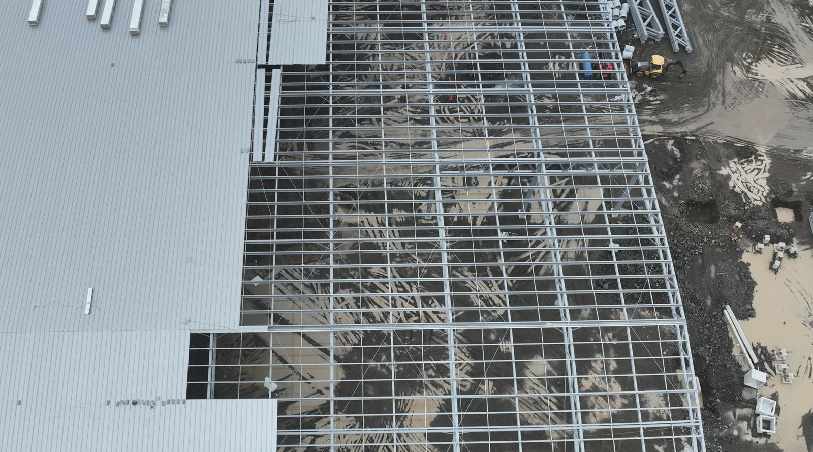 Vista aérea de la estructura de acero y concreto de una nave en construcción.